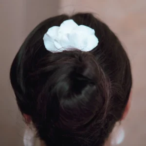 Peigne pétales blancs en porcelaine porté au dessus d'un chignon. Accessoire cheveux de cérémonie.