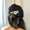 Coiffure bohème chic demi queue surmontée d'un peigne de fleurs de porcelaine froide et perles dorées