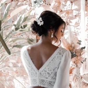 Mariée bohème coiffure cgignon bas avec épingles fleurs de porcelaine blanches