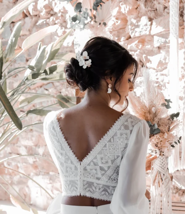 Mariée bohème coiffure cgignon bas avec épingles fleurs de porcelaine blanches
