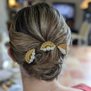 Coiffure mariage chignon bas. Couleur des cheveux blonds cendrés. Accessoire cheveux forme éventail or et perles nacrées
