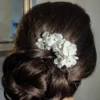 Coiffure chignon mariage Peigne fleurs porcelaine sur le côté du chignon. Épingle chignon mariage