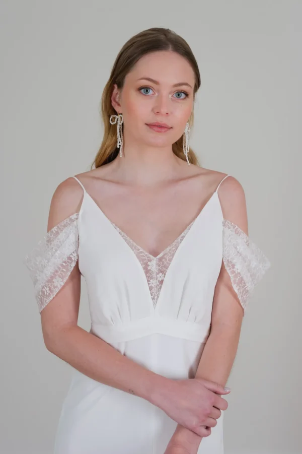 Mariée naturelle. Robe épurée, dentelle légère, tombé épaule. Boucles d'oreilles pendantes en perles nacrées.