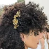 Coiffure Afro les cheveux relevés sur le côté avec un peigne de mariée doré fait main.