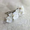 Barette constituée de fleurs de porcelaine. Les fleurs de type rose sont très légères. Fleurs de porcelaine de couleur blanche