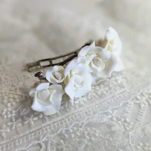Barette constituée de fleurs de porcelaine. Les fleurs de type rose sont très légères. Fleurs de porcelaine de couleur blanche