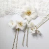 Set de 3 Pics à chignon, fleurs blanches de porcelaine et perles dorées pour un look de mariée bohème chic. Accessoire cheveux mariage.