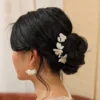 Coiffure de mariée chignon bas. cheveux bruns. Coiffure avec accessoires by Marguerite epingles fleurs en porcelaine froide.