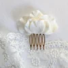 Bijou de cheveux orné de pétales de porcelaine blancs.