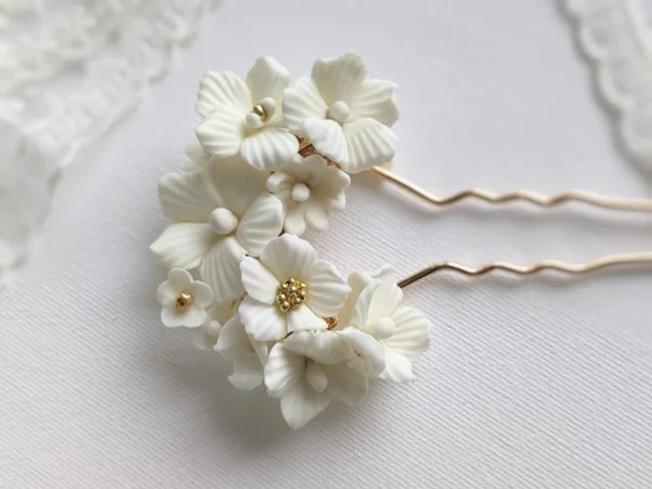 Epingle à chignon mariage fleurs de porcelaine froide blanches et perles dorées