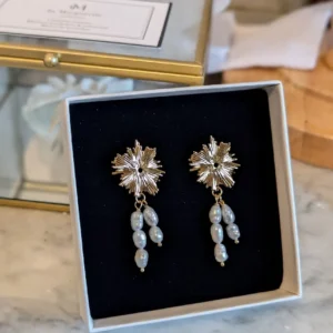 Boucles d'oreilles ALBANE dans leur écrin : puce soleil dorée à l'or fin et perles d'eau douce naturelles pendantes, by Marguerite