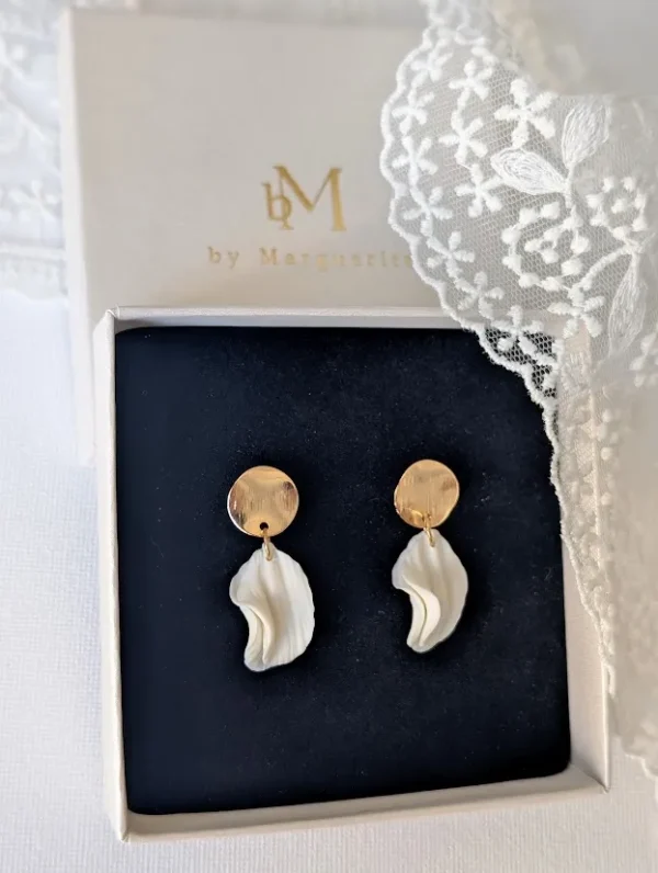 Boucles d'oreilles CHLOÉ 5 <p>Sous une puce en or brossé, les pétales de porcelaine froide de Chloé bougent librement. Des boucles d'oreilles discrètes, pensées pour un mariage civil ou une tenue épurée.</p><ul><li>Faites main dans mon atelier du Pays Basque</li><li>Puce en plaqué or 18k brossé, pétales en porcelaine froide</li><li>Environ 3,3 cm · 2 g</li></ul> Gros plan sur CHLOÉ dans l'écrin : pétale de porcelaine froide en forme de goutte ondulée
