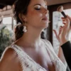 Maquillage de la mariée. Robe dentelle encolure V. Boucles d'oreilles mariage pendantes. Bijou de mariage argenté
