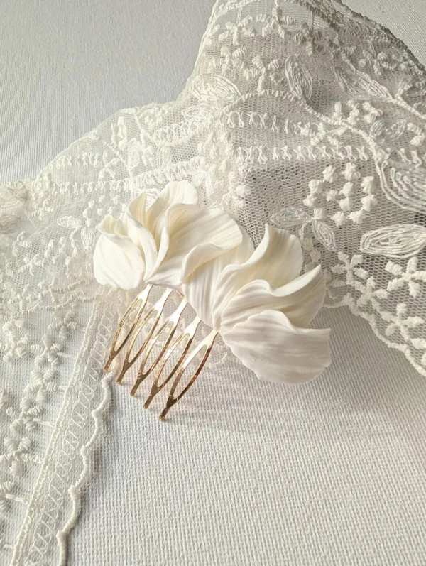 Peigne MARIA 1 <p>MARIA, c'est une branche de pétales blancs en porcelaine froide, longue d'environ 8 cm, montée sur un peigne doré. Ce peigne pétales blancs porcelaine se pose aussi bien sur le côté d'un chignon que sur une demi-coiffure.</p><ul><li>Fait main dans mon atelier du Pays Basque</li><li>Pétales en porcelaine froide, peigne en laiton doré</li><li>Ornement d'environ 8 × 3 cm</li></ul> Peigne de mariée MARIA dans son écrin : pétales de porcelaine froide en mouvement et texturés, peigne doré, by Marguerite