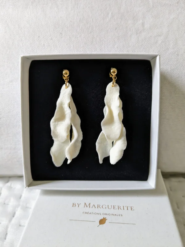 Boucles d'oreilles mariage pendantes. Or et pétales de porcelaine froide. Mariée moderne et élégante