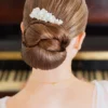 Coiffure mariage minimaliste tendance. Chignon bas travaillé et peigne de porcelaine et perles
