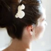 Idée coiffure mariage. Chignon haut orné d'un peigne pétales de porcelaine et perles fines ivoire.