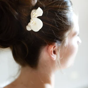 Idée coiffure mariage. Chignon haut orné d'un peigne pétales de porcelaine et perles fines ivoire.