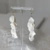 Boucles d'oreilles pendantes mariage blanches. Cascade de pétales de porcelaine.