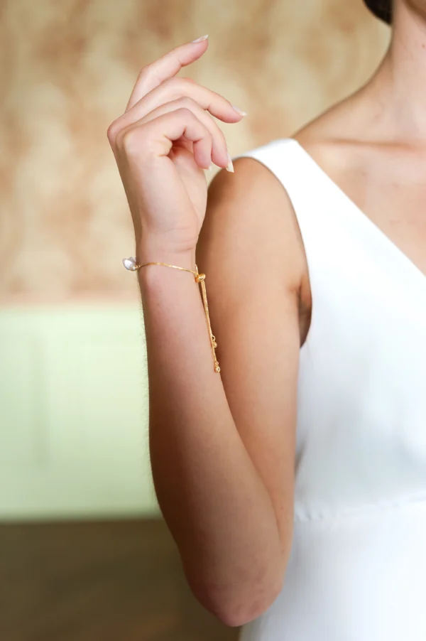 Mariée qui porte un bracelet réglable doré ornée de 4 perles baraoques naturelles