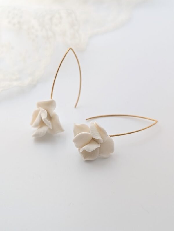 Boucles d'oreilles APOLLINE 1 Apolline, c'est un bouton de fleur en porcelaine froide, posé sur un long crochet fin qui traverse le lobe. Des boucles d'oreilles aériennes, pour les mariées qui aiment le naturel. <ul> <li>Faites main dans mon atelier du Pays Basque</li> <li>Long crochet en acier inoxydable 304, doré à l'or fin 14k ou argenté</li> <li>Fleur de 1,5 cm · longueur d'environ 5 cm · 2 g</li> </ul> boucles d oreilles mariage unique avec petite fleur de porcelaine