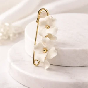Attache-traîne mariée DIANE : fleurs blanches en porcelaine froide sur une épingle dorée, by Marguerite