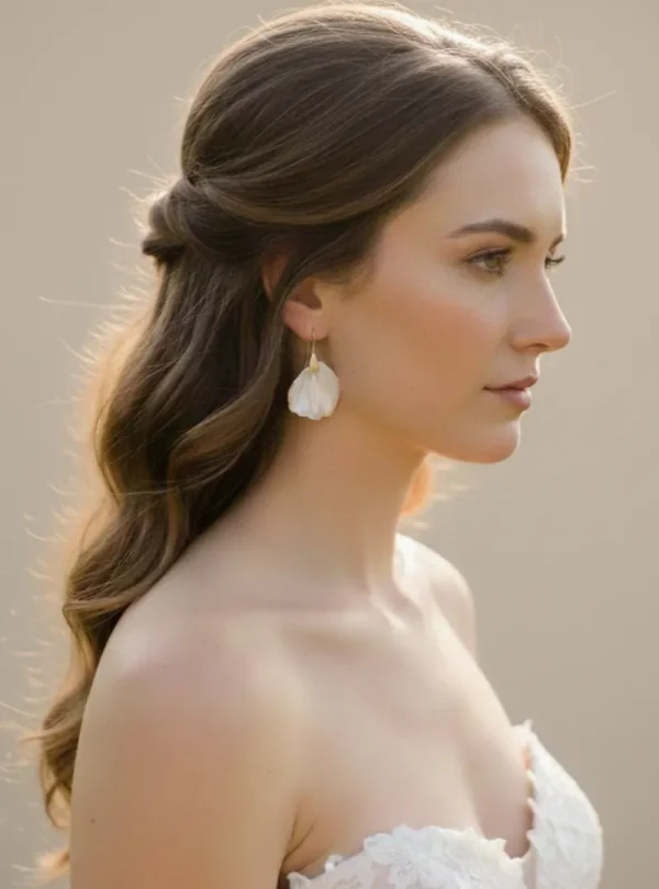 Mariée aux cheveux longs ondulés en demi-queue portant les boucles d'oreilles VIVIENNE