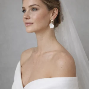 Mariée élégante et moderne avec voile et boucles d oreilles tendance en porcelaine et or.