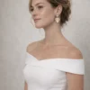 Mariée en robe à épaules dénudées et chignon bas portant les boucles d'oreilles VICTORIA dorées