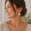 Boucles d’oreilles mariage Kate portées par une femme, avec goutte en porcelaine et cristaux, apportant une touche élégante et lumineuse à une tenue de mariée.