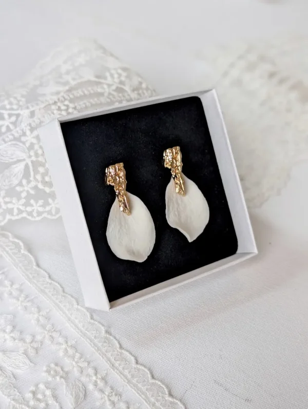 Boucles d'oreilles ROXANNE dans leur écrin noir, posé sur une dentelle