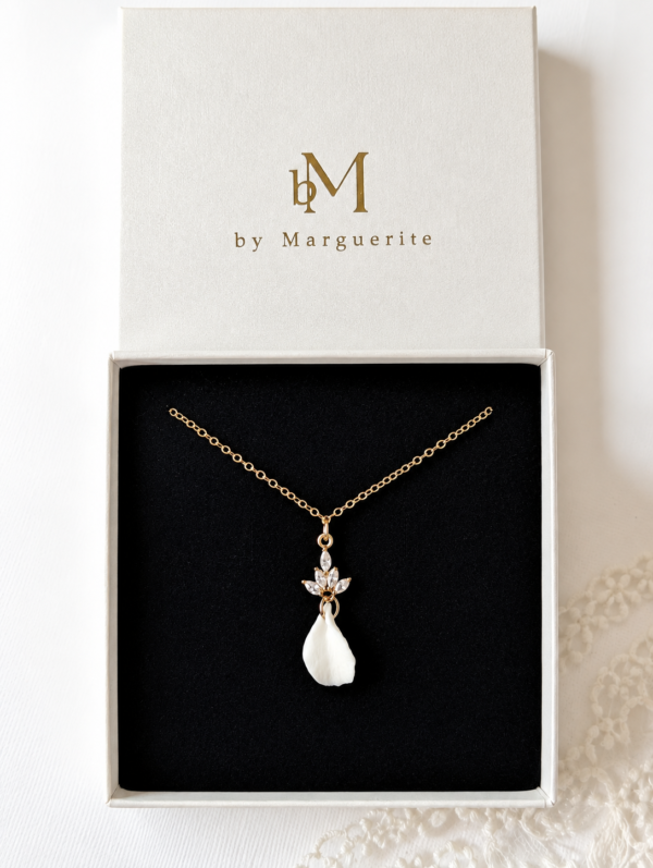 Collier mariée pétale porcelaine NOÉMIE : pétale blanc en porcelaine froide sous un motif doré serti de trois zirconiums, présenté dans son écrin, by Marguerite