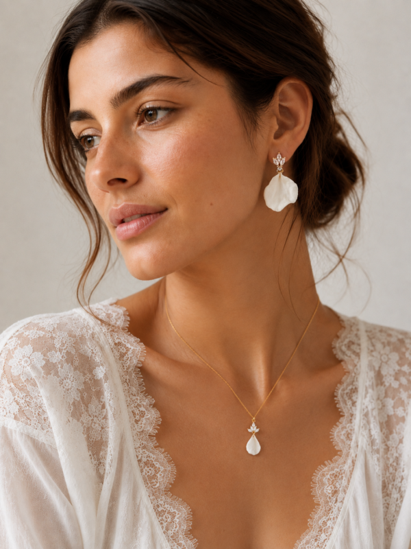 Collier NOÉMIE porté avec les boucles d'oreilles assorties, sur un décolleté en dentelle