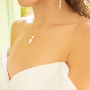 Mariée en robe bustier portant le collier VIVIENNE et les boucles d'oreilles ADÉLAÏDE, perle et pétale nacré, by Marguerite