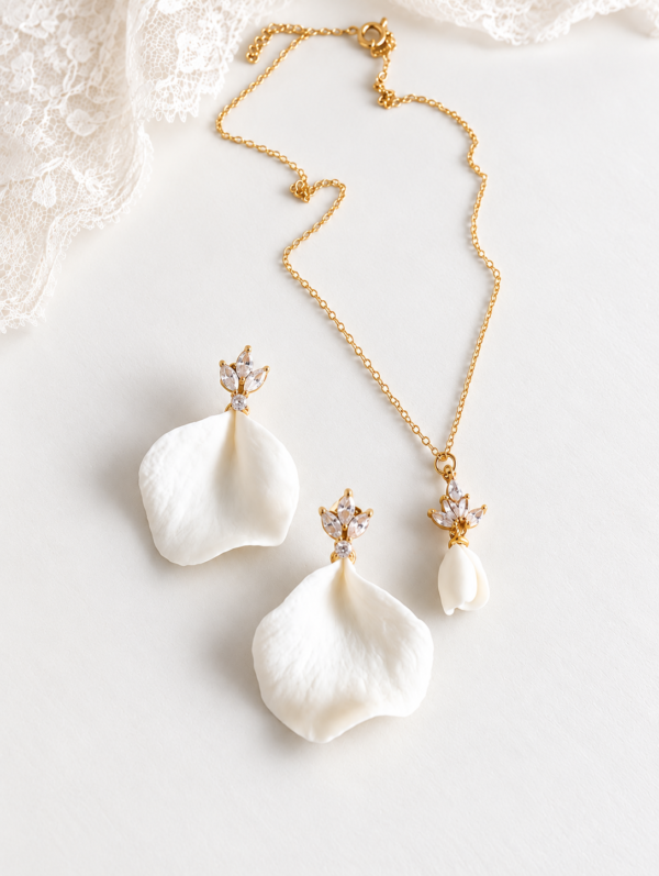 Boucles d'oreilles NOÉMIE 12 Noémie associe la douceur mate de la porcelaine à une étincelle de lumière. Un pétale de porcelaine froide pend sous une petite puce fleur sertie de cristaux, pour des boucles d'oreilles discrètes. <ul> <li>Faites main dans mon atelier du Pays Basque</li> <li>Puce plaquée or 18k ou en laiton argenté, zircone cubique, pétale en porcelaine froide</li> <li>Pétale de 2,5 × 2,3 cm · puce de 1 × 0,8 cm</li> </ul> Parure bijoux de mariage en porcelaine froide blanche et cristaux avec collier assorti