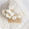Peigne de mariée GARANCE posé sur une dentelle : cinq fleurs blanches en porcelaine froide au cœur de perle dorée, by Marguerite