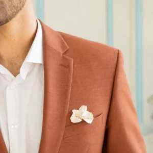 Boutonnière de marié VIVIENNE glissée dans la poche poitrine d’une veste terracotta, chemise blanche, by Marguerite