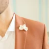 Boutonnière pour témoin de mariage VIVIENNE piquée au revers d’une veste terracotta, fleur nacrée, by Marguerite