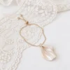 Bracelet VIVIENNE posé sur une dentelle : chaîne réglable dorée, curseur et petits zirconiums aux extrémités, by Marguerite