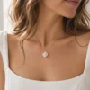 Collier APOLLINE porté avec un haut blanc à encolure carrée : petite fleur de porcelaine au creux du cou, by Marguerite