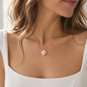 Collier APOLLINE porté avec un haut blanc à encolure carrée : petite fleur de porcelaine au creux du cou, by Marguerite