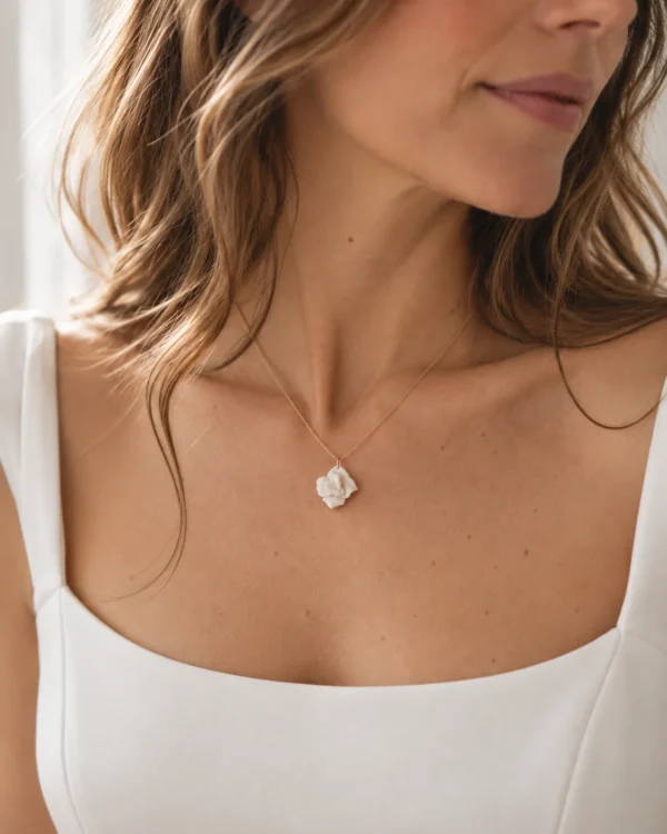 Collier APOLLINE porté avec un haut blanc à encolure carrée : petite fleur de porcelaine au creux du cou, by Marguerite