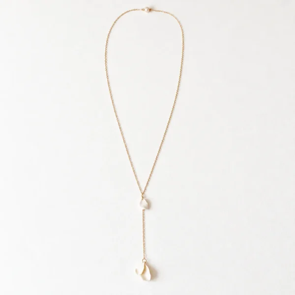 Collier de dos DIANE 7 Une perle ronde à l'avant, et dans le dos trois petits pétales de porcelaine qui bougent au moindre pas : DIANE est un collier de dos de mariage aux pétales de porcelaine, léger et délicat. Sa chaîne fine dessine une ligne de lumière le long d'une robe dos nu, du jour J aux soirées d'été. <ul> <li>Fait main au Pays basque, en France</li> <li>Chaîne gold filled 14 carats, perle de culture, pétales en porcelaine froide</li> <li>Longueur 65 ou 70 cm, pendant de 10 cm · sur mesure possible</li> </ul> Collier de dos DIANE : collier de dos mariage à pétales de porcelaine et perle de culture, chaîne fine dorée, by Marguerite