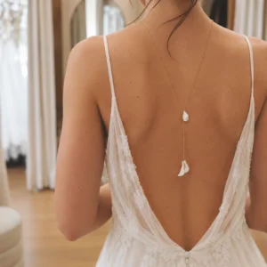Collier de dos DIANE porté avec une robe de mariée dos nu en dentelle, pétales blancs le long du dos, by Marguerite