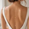 Collier de dos EMMA porté avec une robe de mariée dos nu : chaîne dorée le long du dos, fleur dorée et perle d'eau douce, by Marguerite