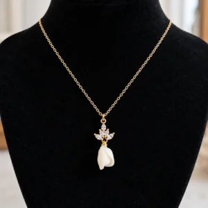 Collier KATE sur un buste noir : fine chaîne gold filled, pendentif de cristaux et bouton de fleur en porcelaine blanche, by Marguerite