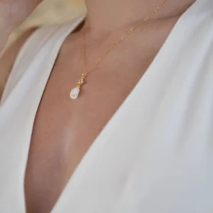 Collier KATE porté avec une robe blanche à décolleté en V : petit bouton de fleur en porcelaine et cristaux sur chaîne dorée, by Marguerite