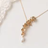 Collier NORA cascade : cinq fleurs dorées striées et perle d'eau douce naturelle près d'une dentelle, by Marguerite
