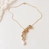 Collier NORA cascade : collier mariée fleurs dorées et perle d'eau douce, chaîne fine sur fond clair, by Marguerite