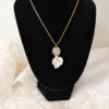 Collier STELLA sur un buste noir : fine chaîne gold filled, pendentif serti et pétales de porcelaine blanche, by Marguerite
